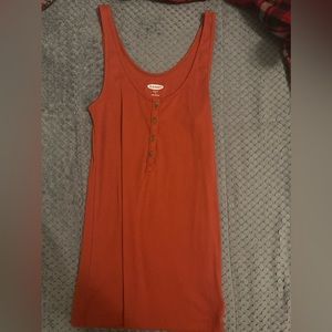 An orange tank top with brown buttons